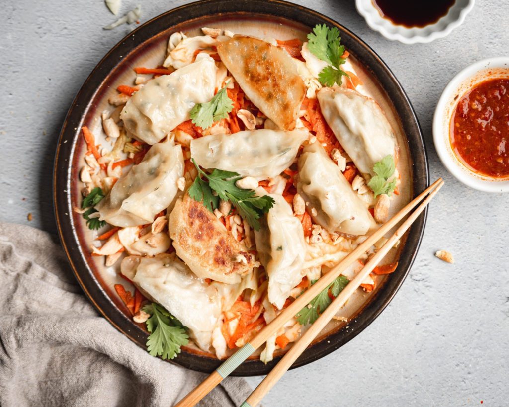 Hungry Planet pork gyoza stir fry with carrots, cilantro, and peanuts in a dish with chopsticks