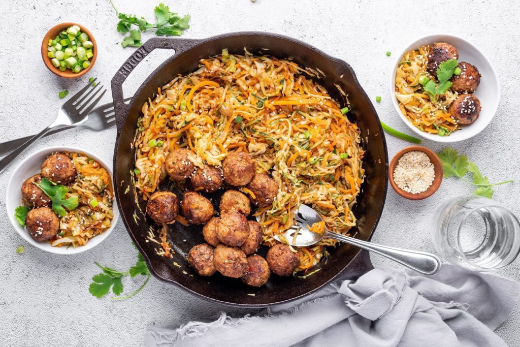 Hungry Planet Thai meatballs and veggie noodles in bowls served out of a cast iron pan